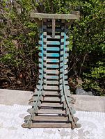 Front view of wooden slat plant stand showing full height and curved slat construction