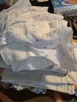 Stack of white pillowcases with small floral motifs