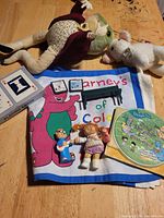Full lot overview on table showing plush toys, cloth, disc, cards and figurines