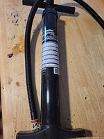 Full view of black paddleboard pump with hose attached