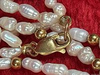 Close-up of clasp, gold beads, and baroque pearls