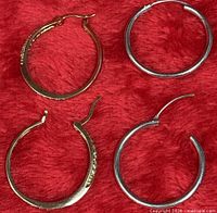 Four sterling silver hoop earrings, two distinct pairs