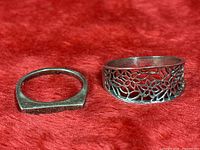 Both sterling silver rings side by side on red background