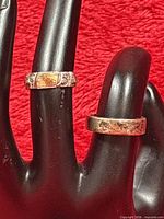 Two rings displayed on black hand form