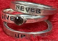 Three stacking rings with Never Give Up wording and smoky quartz