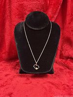 Necklace on velvet bust displaying pendant and chain