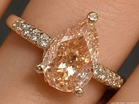 Pear-cut champagne lab diamond ring on finger showing setting and accent stones