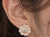 Earring worn on ear showing scale and design