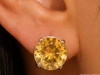 Close-up of a single citrine stud earring in ear for size and setting clarity