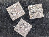 Close-up of three square diamonds showing cut and brilliance