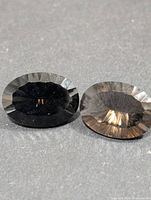 Front view of two oval smokey quartz gemstones showing color and faceting