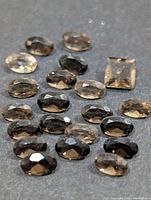 Group of faceted smoky quartz stones showing shapes and quantity