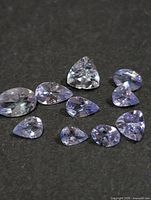 All ten faceted tanzanite gemstones displayed on dark background