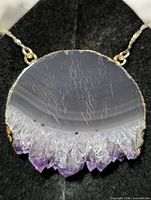 Front close-up of agate and quartz pendant showing banding and purple crystal tips