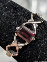 Front view showing emerald-cut garnet and infinity design