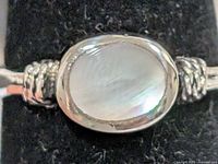 Front view of ring showing oval mother-of-pearl cabochon and silver bezel