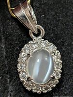Front view of oval moonstone and CZ halo pendant