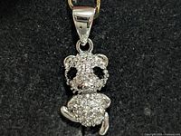 front view of silver panda pendant showing stones and bail