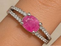 Front view of silver ring with oval ruby and CZ accents
