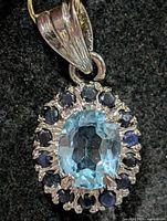 Pendant front showing blue topaz centre and sapphire halo