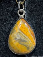 Front view of teardrop bumblebee jasper pendant in silver bezel