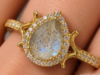 Front view of pear-shape labradorite ring with CZ halo on finger for scale