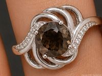 Front view of ring on finger showing center smoky quartz and CZ accents