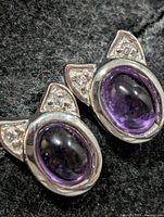front view of earrings showing amethyst cabochons and accent stones