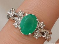 Ring on finger showing green onyx and floral details