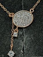 Close-up of oval pavé CZ pendant and chain details