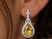 Earring worn on ear showing scale, pear citrine with CZ halo in silver setting