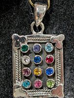 Front view of rectangular silver pendant displaying multi-colour CZ stones