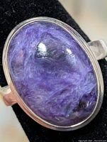 Front view of silver ring with oval purple charoite stone