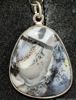 Front view of silver pendant with dendritic opal