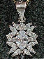 Front view of sterling silver pendant with oval CZ center and halo of marquise and round CZ stones