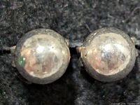 Front view of both spherical silver stud earrings