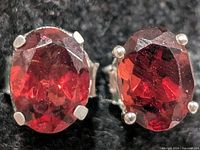 Front view showing oval faceted garnet stones in silver prongs