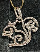 Front view of polished silver squirrel pendant with bail