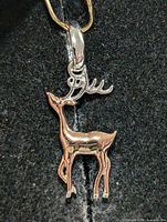 Front view of two-tone reindeer pendant showing body, antlers and bail