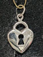 Front view of heart lock silver pendant showing keyhole cutout and bail