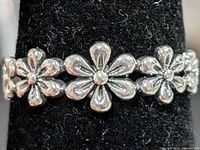 Front view showing three central daisy motifs on silver band