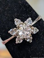 Front view of silver ring showing floral cluster of clear stones