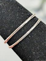 Double-band silver ring on display mandrel showing parallel wires