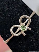 Close-up front view of bow motif and green stone