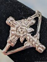 Front view showing cross and rose design on silver ring