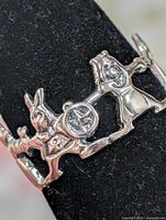 Close-up front view showing rabbit with pocket watch and girl silhouettes