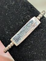 Front view of ring showing rectangular bar accent and beaded band