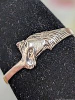 Front view of silver horse head ring on display mandrel