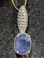 Front view of silver pendant showing sapphire and CZ pavé bail
