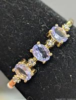 Close-up of ring top showing three tanzanite stones and clear accents